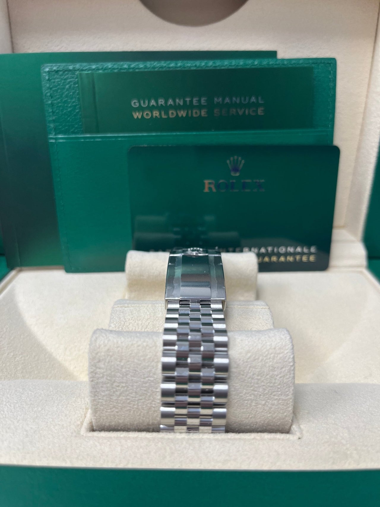 The Rolex GMT-Master II "The Batman" beside its green Rolex box on a steel bracelet. Clasp closeup.