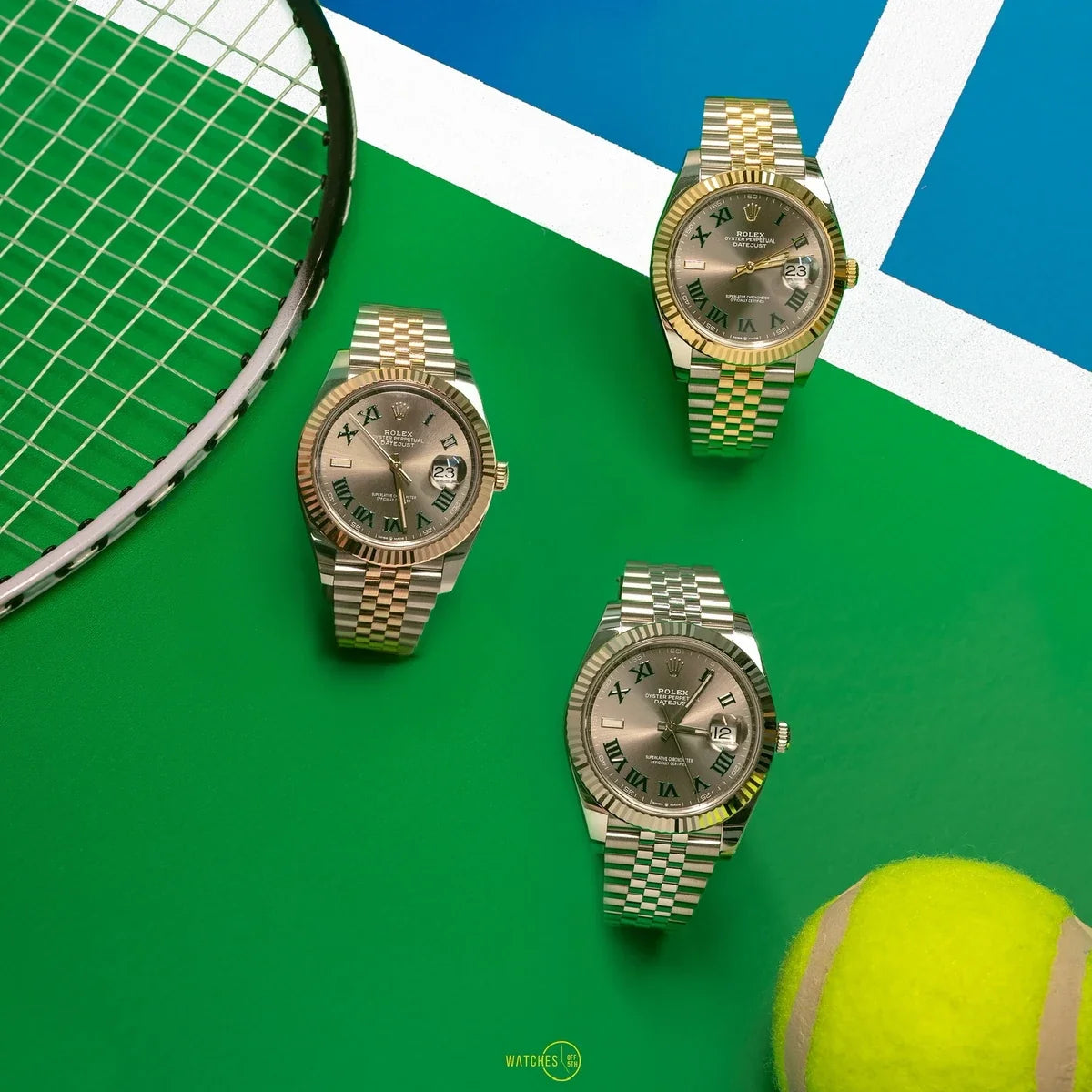 Three Rolex Datejust watches with slate Wimbledon dials and green Roman numerals in Yellow Rolesor, Everose Rolesor and White Rolesor on a tennis court