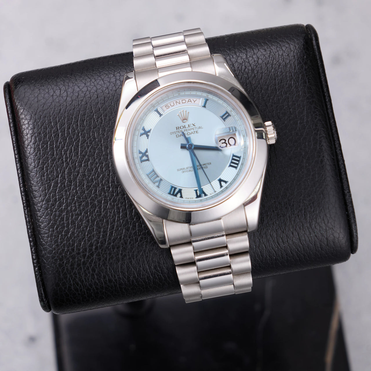 Rolex Day-Date II 41mm Platinum Ice Blue Concentric Roman Dial Smooth Bezel President Bracelet (Ref 218206) - front view on a black leather display stand
