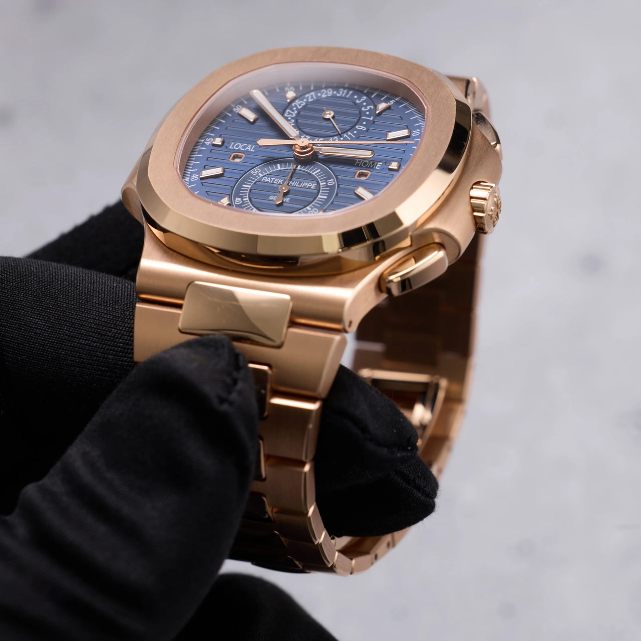 Patek Philippe Nautilus Travel Time Chronograph 18K Rose Gold Blue Dial Ref 5990/1R-001 - angled dial view held in hand