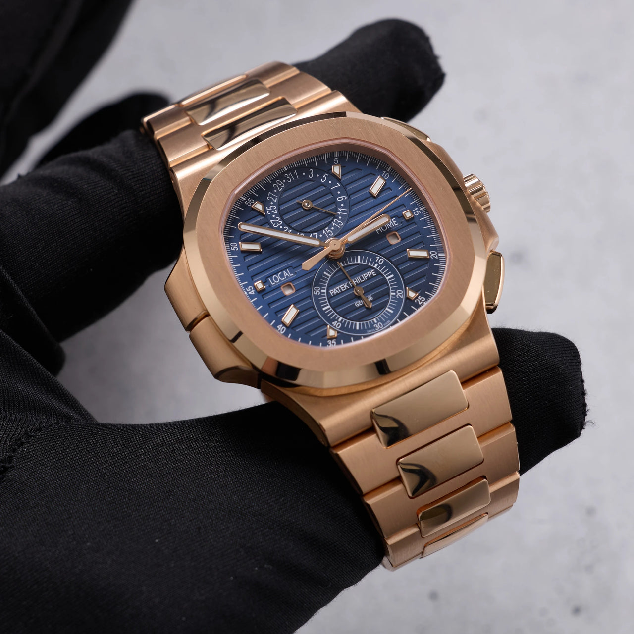 Patek Philippe Nautilus Travel Time Chronograph 18K Rose Gold Blue Dial Ref 5990/1R-001 - angled dial view held in hand