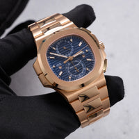 Thumbnail for Patek Philippe Nautilus Travel Time Chronograph 18K Rose Gold Blue Dial Ref 5990/1R-001 - angled dial view held in hand