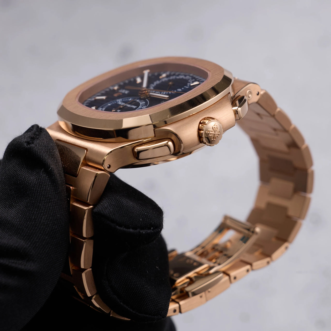 Patek Philippe Nautilus Travel Time Chronograph 18K Rose Gold Blue Dial Ref 5990/1R-001 - angled crown side view held in hand