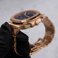 Thumbnail for Patek Philippe Nautilus Travel Time Chronograph 18K Rose Gold Blue Dial Ref 5990/1R-001 - angled crown side view held in hand