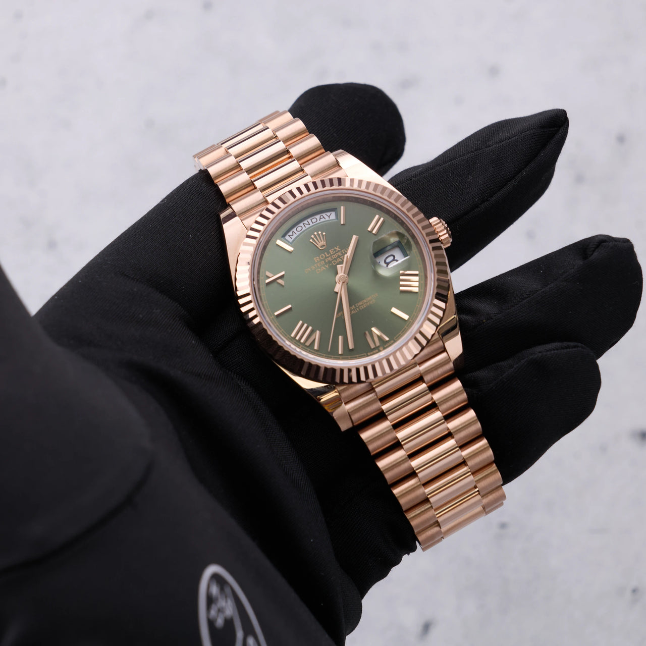 Rolex Day-Date 40mm 18K Everose Gold Olive Green Roman Dial Fluted Bezel President Bracelet (Ref 228235) - dial view held in hand