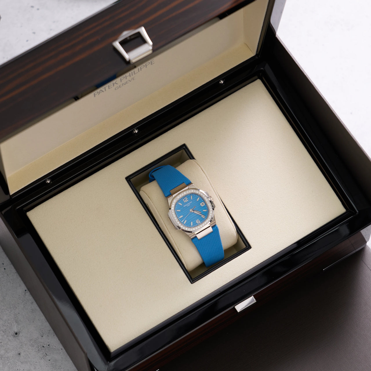 Patek Philippe Nautilus 32mm 18K White Gold Azure Blue Dial Diamond Bezel Ref 7010G-013 - angled in Patek Philippe box