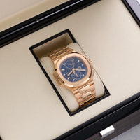 Thumbnail for Patek Philippe Nautilus Travel Time Chronograph 18K Rose Gold Blue Dial Ref 5990/1R-001 - angled view in Patek Philippe presentation box