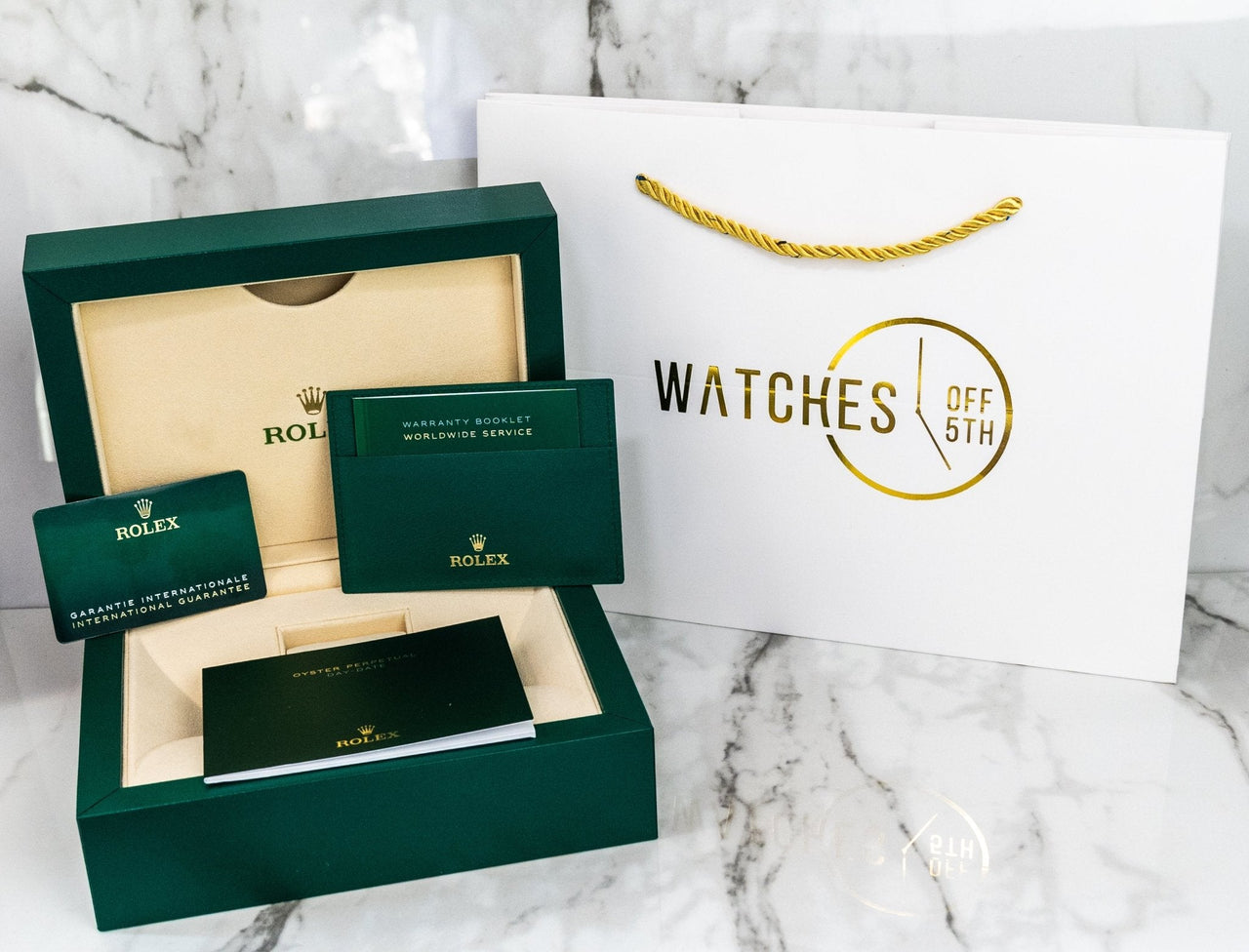 Official Rolex green presentation box with warranty card, and WatchesOff5th shopping bag. 
