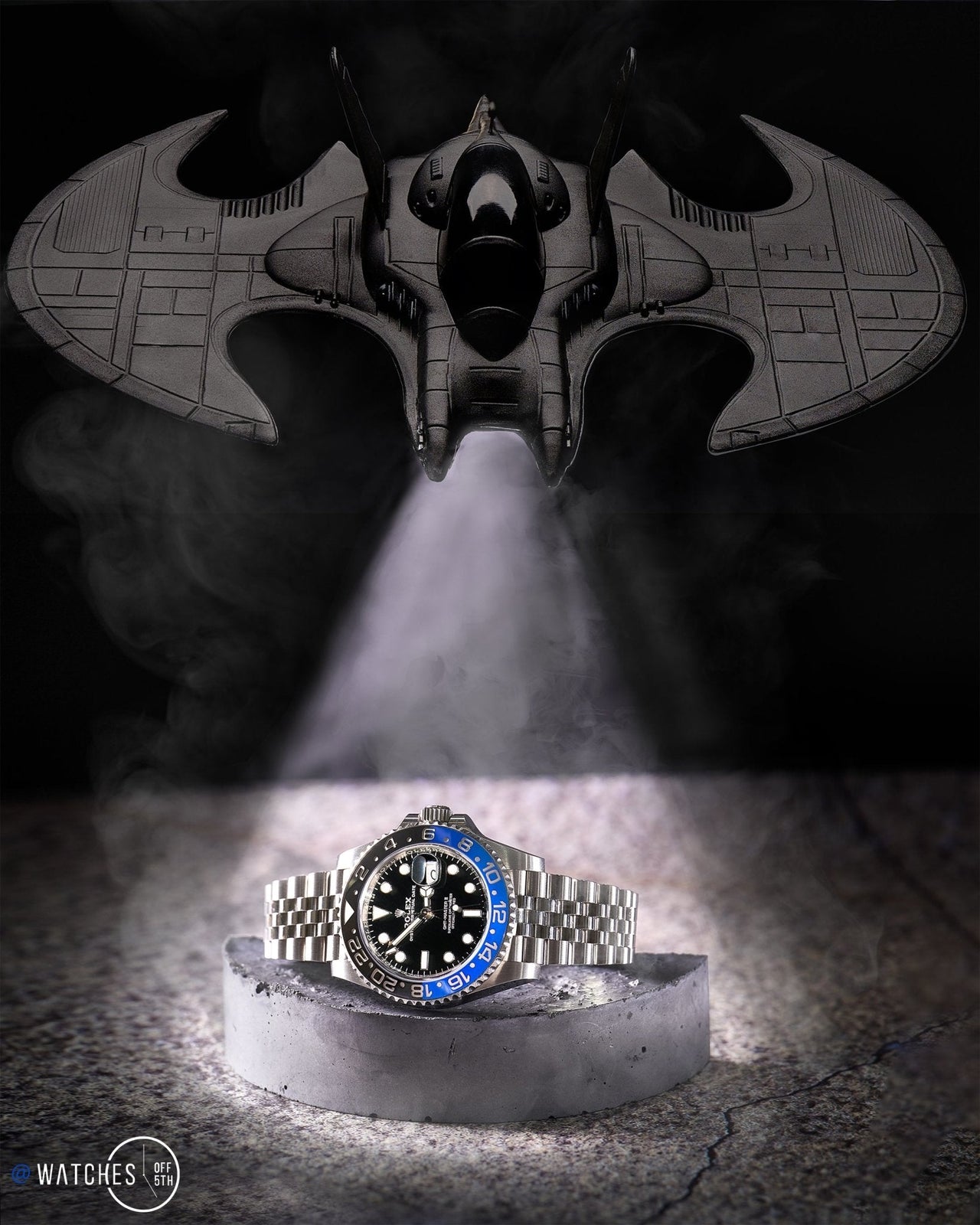 Creative depiction of the Rolex GMT-Master II "The Batman" with a themed background. Dark, ominous tone with a spotlight shining on the watch. 