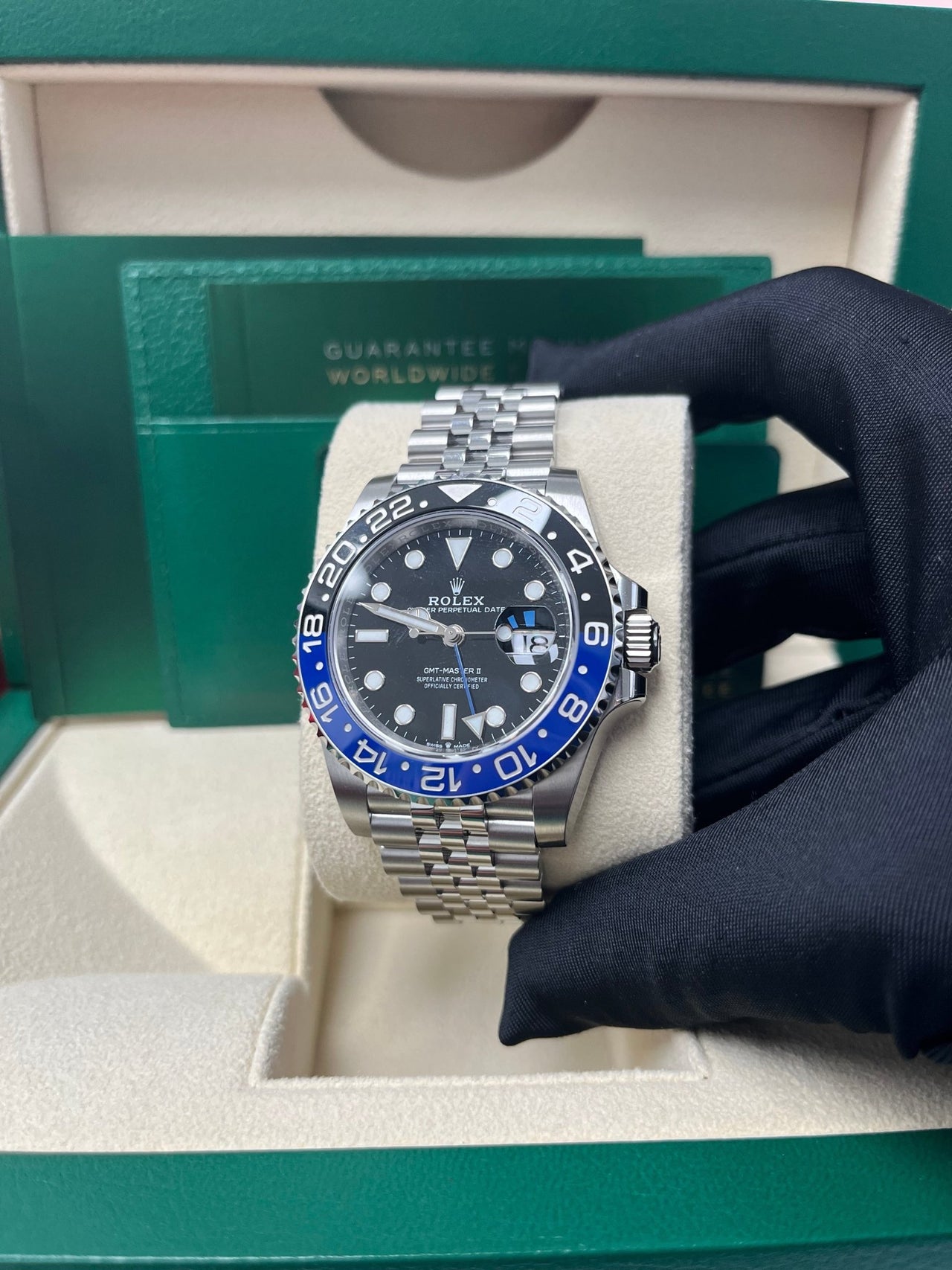 A person presenting the Rolex GMT-Master II "The Batman" with black and blue bezel in its box